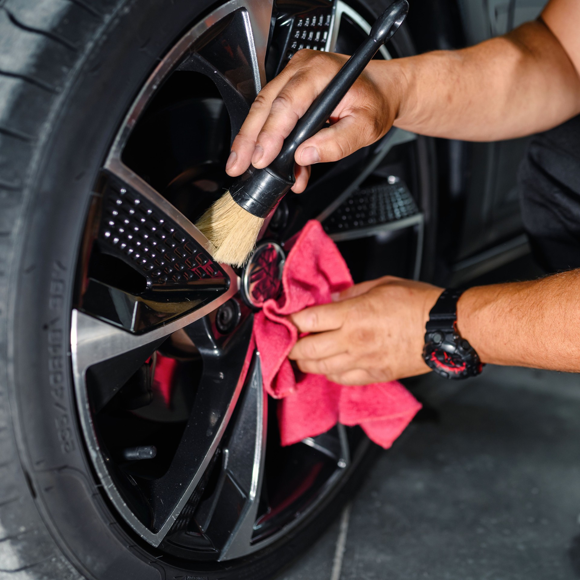 Professional worker cleaning car rim